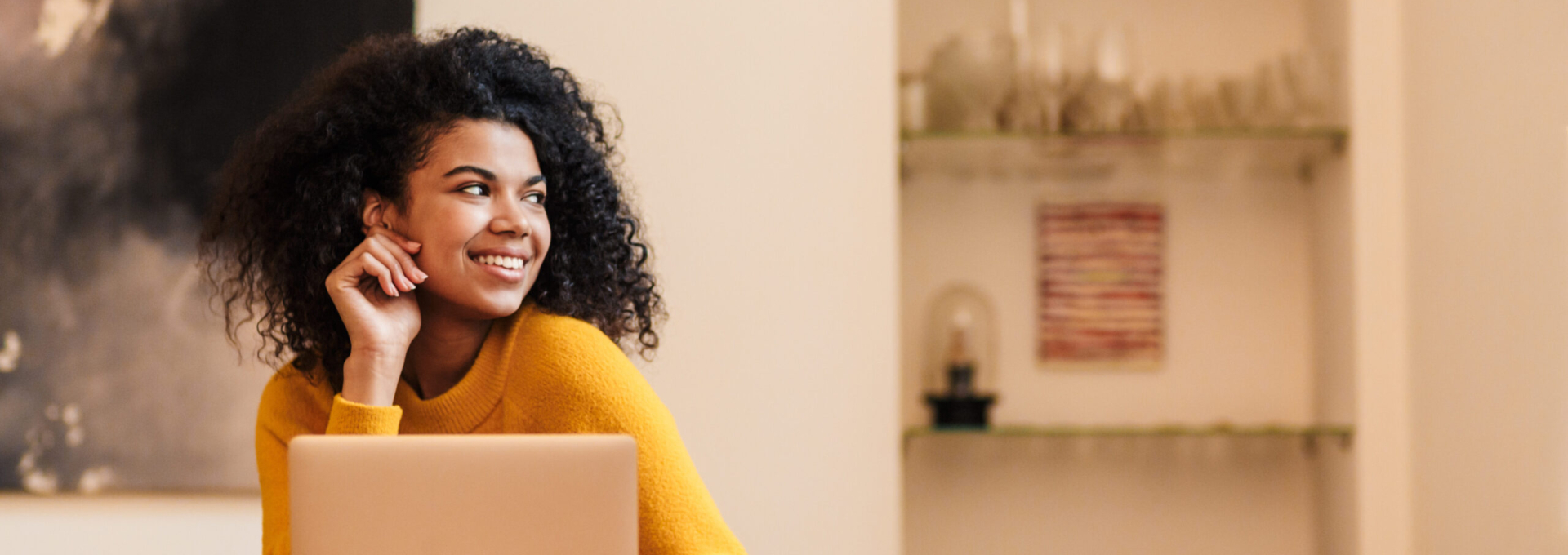 Image of african american woman using laptop while sitting at ta